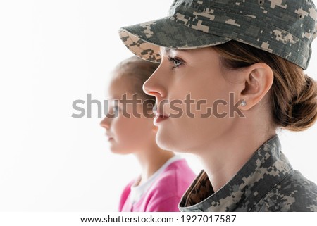 Side view of soldier looking away near daughter on blurred background isolated on white 
