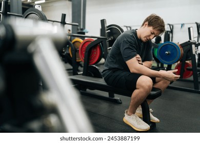 Side view of sportsman having accident injury and hurt at arms while workout with barbell weight training at gym. Athletic man suffering from muscle injury exercising at sport club. - Powered by Shutterstock