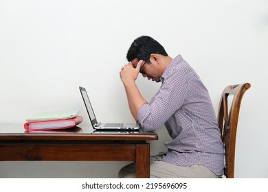 Side View Of Stressed Asian Man Lower His Head In Front Of Laptop 