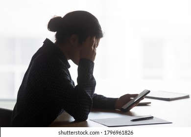 Side View Stressed Young Indian Ethnicity Businesswoman Looking At Phone Screen, Confused About Getting Sms With Bad News. Unhappy Mixed Race Woman Having Problems With Electronic Device In Office.