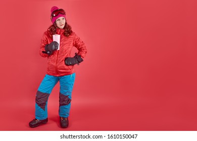 Side View Studio Shot Portrait Woman Wearing Rad Ski Clothes And Standing In Red Background With Tinsel And Ski Mask