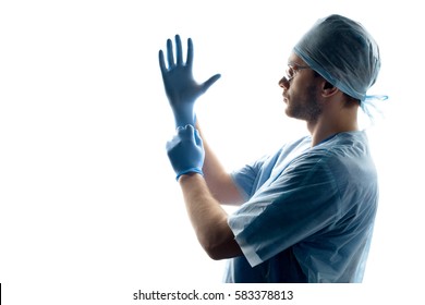 Side View Of Surgeon In Medical Uniform Wearing Gloves Isolated On White