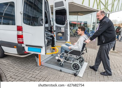 Side view of taxi driver assisting man on wheelchair to board van outside building - Shutterstock ID 627682754