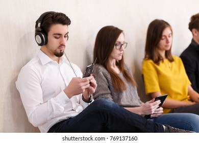 Side view - team of creative outsourcing workers working with gadgets sitting next to each other in creative studio office
