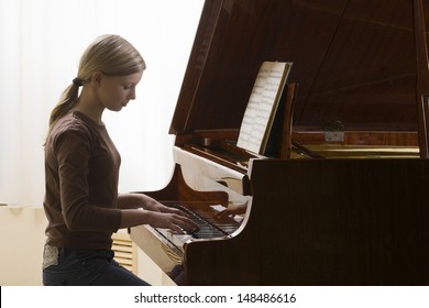 Side view of a teenage girl playing the piano