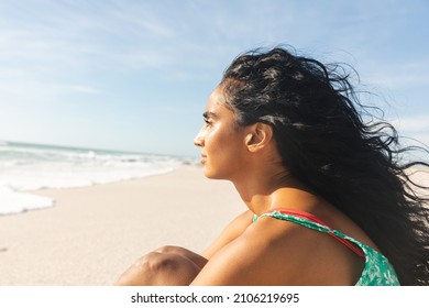 Side view of thoughtful young biracial woman with long black hair looking away at beach. lifestyle and weekend. - Powered by Shutterstock