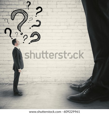 Side view of tiny businessman with drawn question marks looking up to huge one. Small and big businesses concept