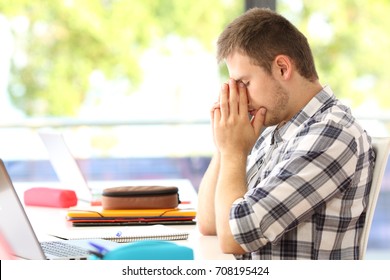 Side view of a tired student alone in a classroom