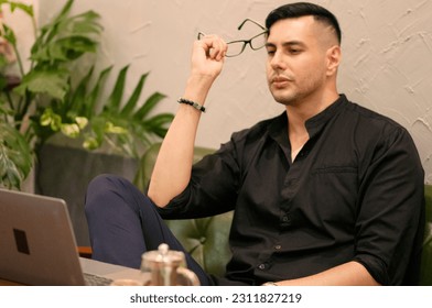 Side view of tired and worried young freelancer looking at notebook screen and thinking of ideas. - Shutterstock ID 2311827219