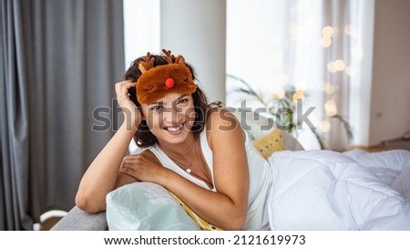 Side view of a tired young woman sleeping on a bed. Close the face of a beautiful sleepy girl wearing a funny eye mask. A high angle view of a woman covering her eyes with a sleeping mask