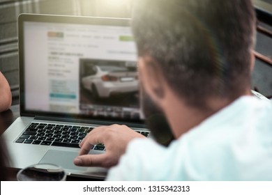 Side View And Top. The Company Of Three Businessmen Are Discussing At The Table In Coffee, Writing In A Notebook, Looking At A Laptop, Satkan With Water, Car Keys, Magazines, A Smartphone, Online.