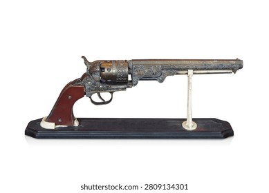 side view two antique and old brass guns with a brown leather grip, placed on a wooden stand against a white background