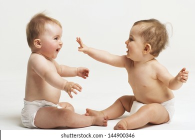 Side View Of Two Babies Playing On White Background