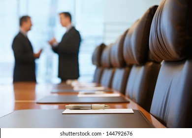 Side view of two blurred businessmen talking in conference room - Shutterstock ID 144792676