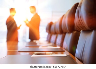 Side view of two blurred businessmen talking in conference room