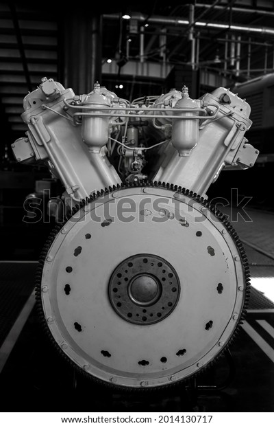 side view of the two cylinder heads of a\
six-cylinder V-shaped internal combustion engine with valve covers\
that lie on a floor. train repair\
shop