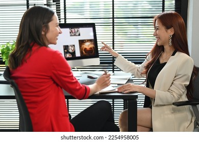 Side view of two female financial advisor preparing presentation for company clients or investors - Shutterstock ID 2254958005