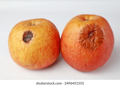 side view of two rotten apples on white background