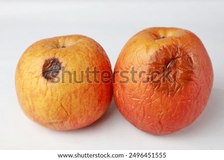 side view of two rotten apples on white background