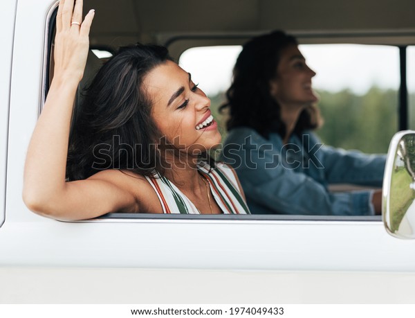 Side view of two women sitting in minivan during a\
summer road trip