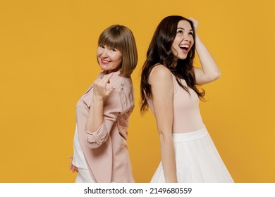 Side View Two Young Stunning Fun Smiling Gorgeous Happy Caucasian Daughter Mother Together Couple Women In Casual Beige Clothes Stand Back To Back Isolated On Plain Yellow Background Studio Portrait