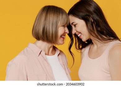 Side View Two Young Tender Happy Lovely Smiling Daughter Mother Together Couple Women In Casual Clothes Hug Touch Forehead Isolated On Plain Yellow Background Studio Portrait Family Lifestyle Concept.