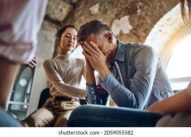 Side View At Upset Man Feel Pain Depression Problem Addiction Get Psychological Support Of Counselor Therapist Coach Diverse People Friend Group Help Patient During Therapy Counseling Session Concept.