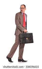 Side View Of A Walking Old Businessman Looking Back Over His Shoulder On White Background