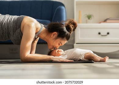 Side View Of Wellness Asian Woman Mom Doing Plank Exercise And Kissing Her Baby At Cozy Home.Happy Healthy Mother Yoga Plank With Newborn Baby Boy Sleep And Lying On Yoga Mat.Yoga Mom And Baby Concept