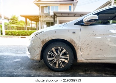 Side View Of White Car With Dirty Car Mud Stain. Car Dirty Headlight, Wheel, Bumper And Door Of The Car With Swamp Splashes On A Side Panel.