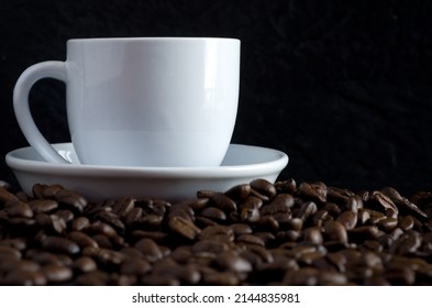 Side View of White Coffee Cup Surrounded with Coffee Beans Horizontal