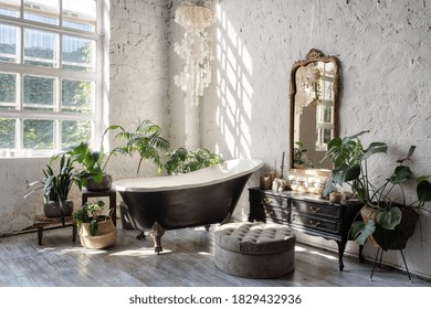 Side View Of White Cozy Bathroom With Black Tub, Wooden Classic Commode, Mirror, Decor, Plants And Interior Design In Boho Chic Style. Concept Of Comfortable And Decorated Room At Home