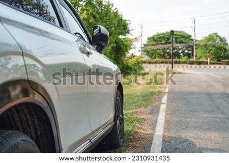 Side view of white modern SUV car with stain asphalt parked on roadside