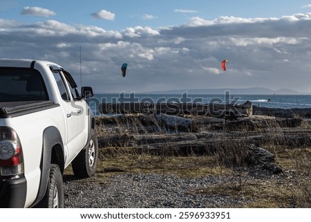 Side view of White pickup 4x4 Offroad truck in nature. Powerful pickup truck on the background of the sea and cloudy sky. Travel photo, nobody, copy space for text
