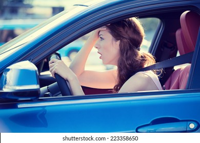Side view window portrait displeased stressed angry pissed off woman driving car annoyed by heavy traffic isolated street background. Emotional intelligence concept. Negative human face expression