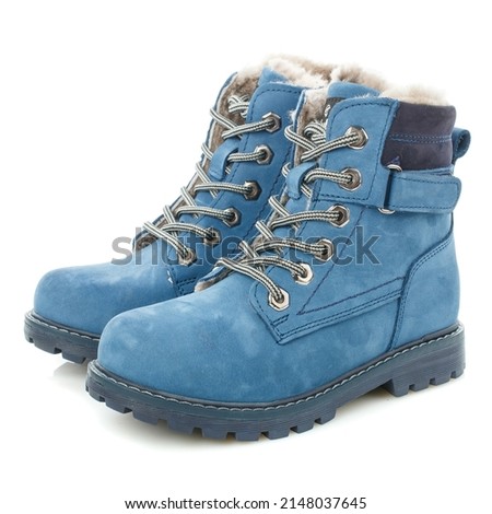 Side view of winter children's warm blue boots with fur for walking. White background.