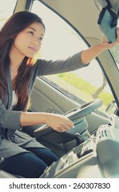 Side View Of Woman Adjusting The Rearview Mirror