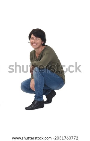 side view of a woman crouching and looking away on white background