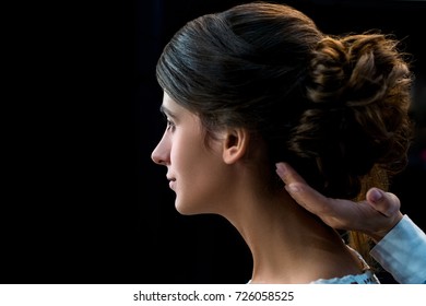 Side View Of Woman Getting Hair Done By Hairstylist Isolated On Black