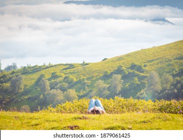 Side View Of Woman Laying Down On The Ground Above The Clouds With Stunning Landscape