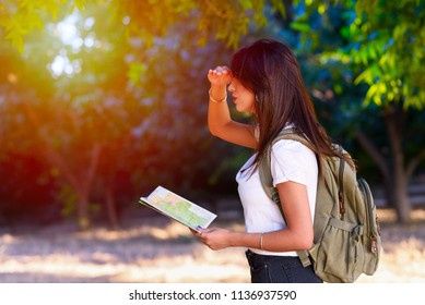 Side View Of A Woman Looking Forward At Sunset Outdoor. Personal Development, Attainment Motivation Career Growth Concept. Portrait Of Beautiful Girl Tourist With Backpack Holding Travel Guide Book.