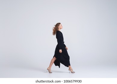 Side View Of Woman Model Walking In Trend Black Dress