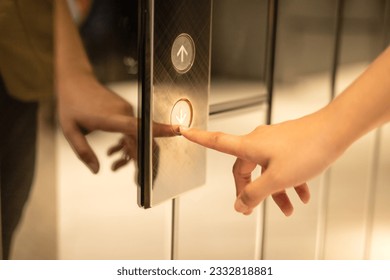 Side view of a woman presses the down button of the elevator in the building with her finger. Finger presses elevator button. Light button. Hand reaches for elevator call button. Elevator concept. - Powered by Shutterstock