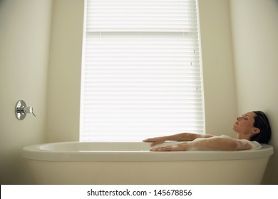Side view of woman resting in bathtub