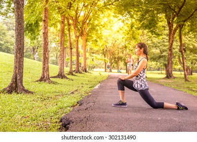 Side View Of Woman Runner Stretching Warm Up With Lunge Stretch Before Running.