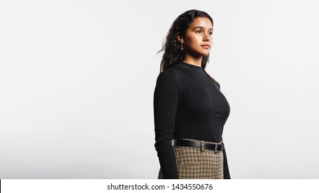 Side View Of Woman Standing Against White Background. Portrait Of Young Woman Looking Away.