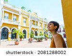 Side view of woman traveling in Cartagena de Indias. Horizontal view of latin woman sightseeing in spanish historic ancient city. Travel to Colombia concept.