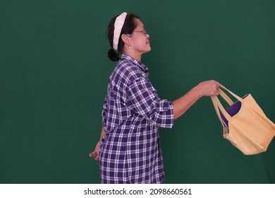 Side View: Woman Wearing Bandana; Carrying Bag.