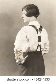 Side view of woman wearing suspenders and men's trousers, 1920s