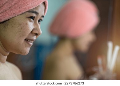 side view of a woman wrapped in a towel on her sari after morning shower.